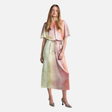 woman wearing a pink, yellow, and green ombre satin midi dress with batwing sleeves and a tie waist