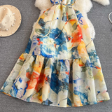 Bottom half of an abstract floral print maxi dress showing the tiered skirt and vibrant print.
