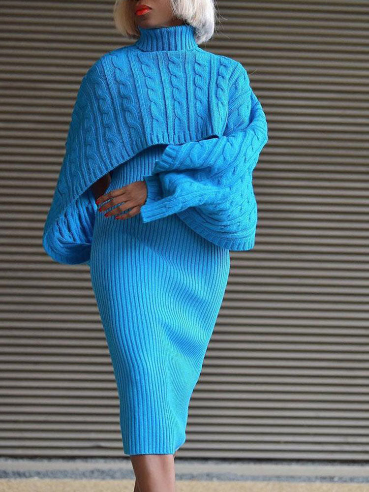 Woman wearing a blue cable knit cropped sweater and a matching ribbed knit midi skirt.