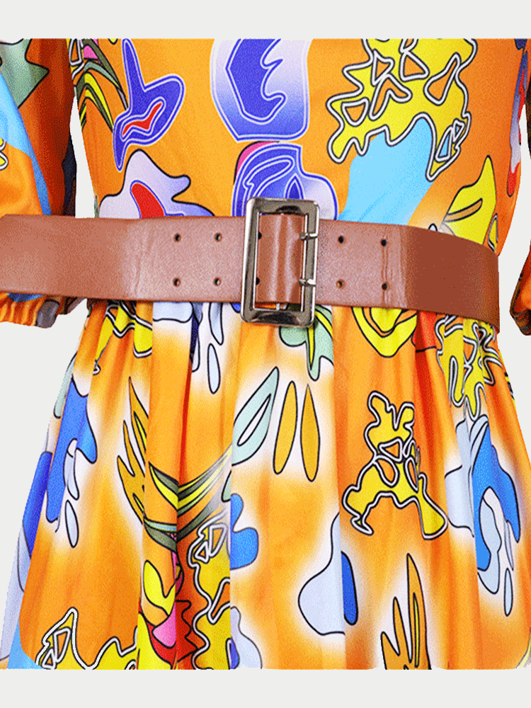 Detail of the wide brown belt with a silver buckle on the abstract print dress