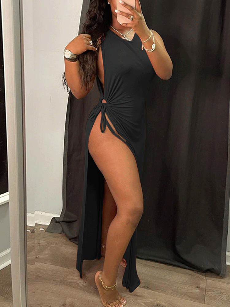 Woman wearing a black sleeveless maxi dress with a high slit and halter neckline, posing in a mirror.