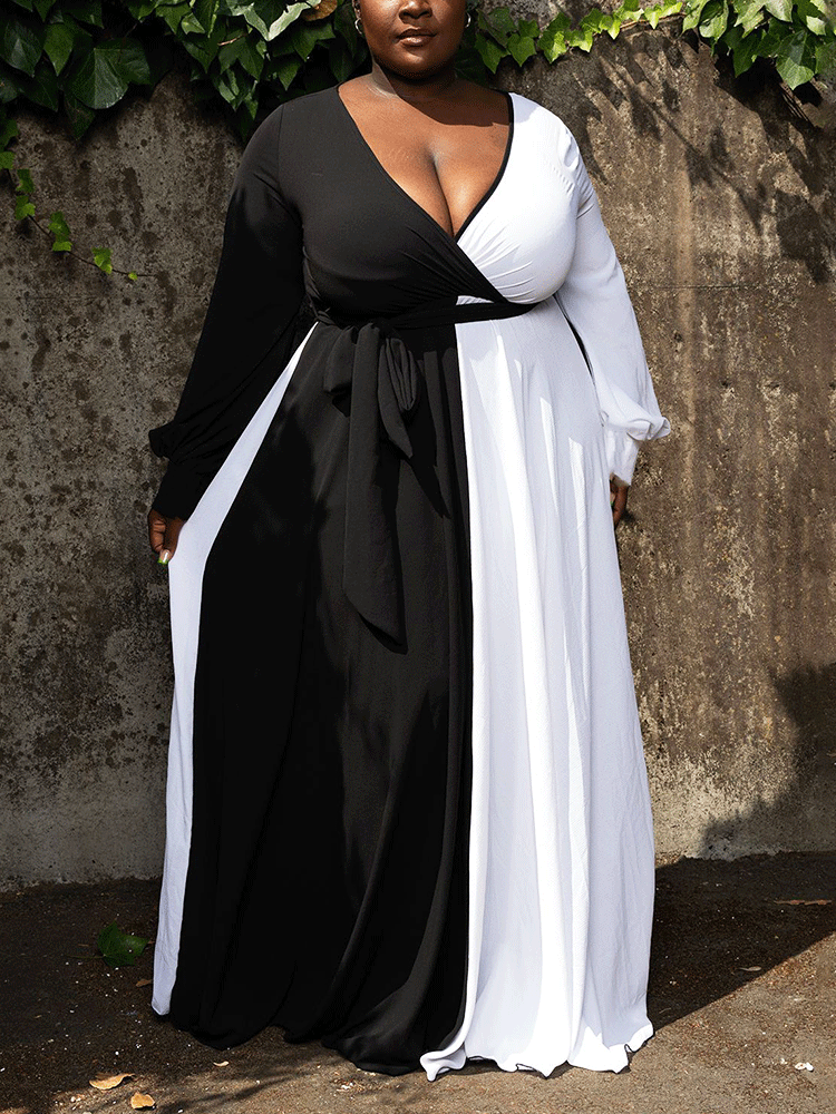 Woman wearing a black and white color-block maxi dress with long sleeves and a V-neck.