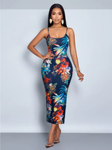 Woman in a floral print bodycon dress with spaghetti straps, standing with one hand on her hip.