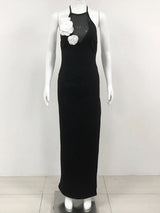 black floor-length halter dress with white floral embellishments displayed on a mannequin