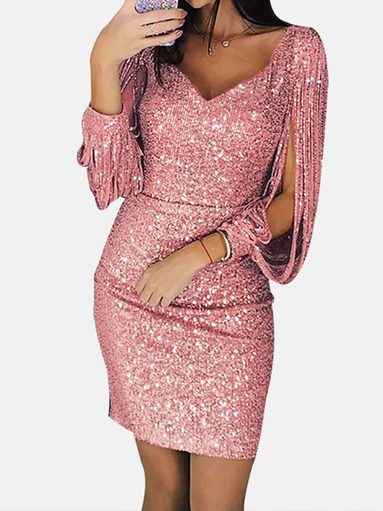 Woman wearing a pink sequin dress with tassel sleeves