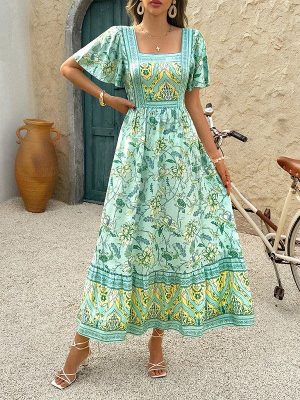Woman wearing a light green floral print midi dress with a square neckline and short puff sleeves.
