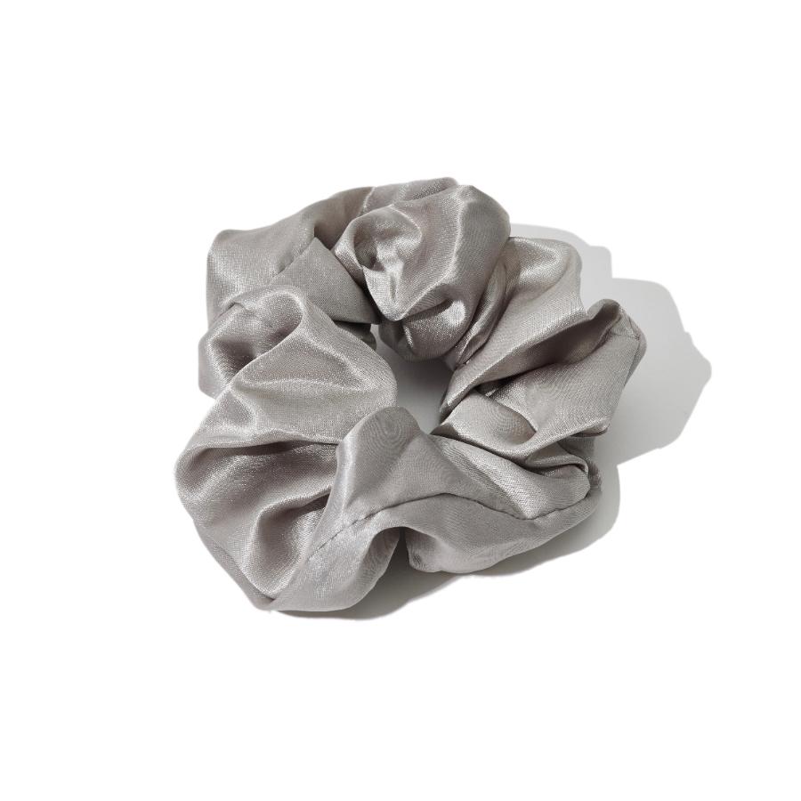 A grey satin scrunchie is shown against a white background.