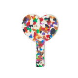 back view of a heart-shaped hand mirror with a multicolored confetti acetate frame