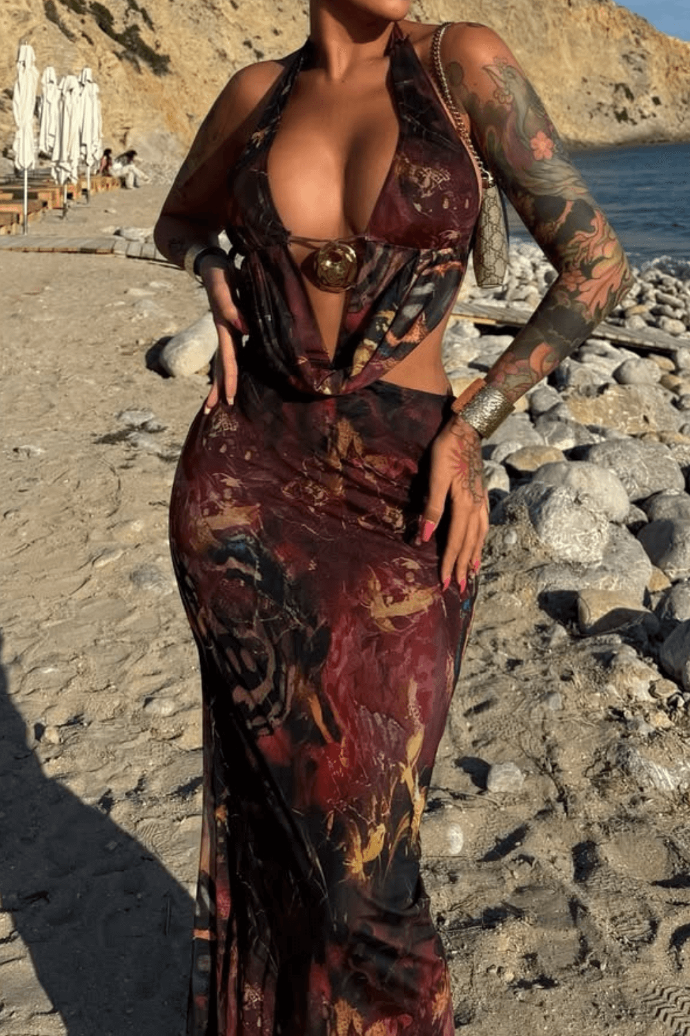 Full body shot of a woman in a printed maxi dress with a halter neckline