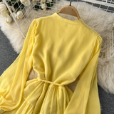 A woman wearing a chic pleated maxi dress with a tiered skirt and puff sleeves. - View 8 | Lwiis