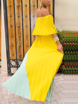 Woman twirling in a yellow and mint green pleated maxi dress
