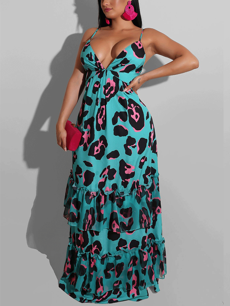 Woman wearing a turquoise maxi dress with a black and pink leopard print, featuring spaghetti straps, a plunging v-neck, and a tiered, ruffled skirt. She is holding a pink clutch and wearing large pink hoop earrings.