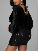 Back view of a black velvet and sequin mini dress with an open back