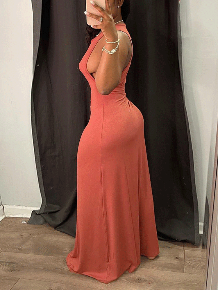 Back view of a woman wearing a rust-colored sleeveless maxi dress with a deep neckline.