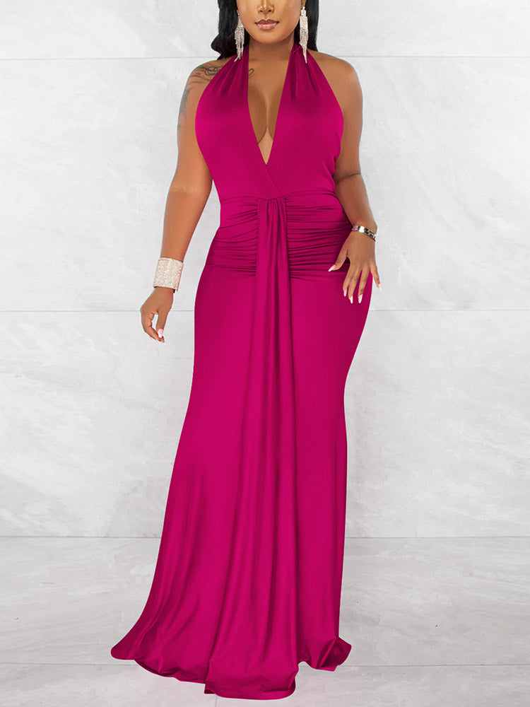 Woman wearing a long fuchsia halter neck dress with a deep V-neck and ruched waist