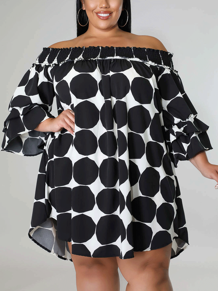 Close-up of a woman wearing a black and white polka dot off-the-shoulder dress, showing the ruffled sleeves.