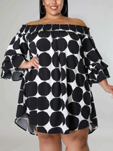 Close-up of a woman wearing a black and white polka dot off-the-shoulder dress, showing the ruffled sleeves.