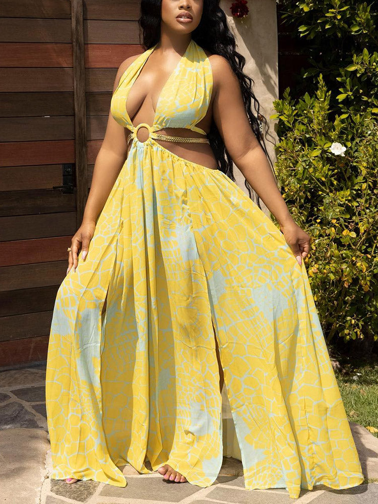 Woman wearing a yellow and blue patterned maxi dress with cut-outs and a high slit, standing outdoors.