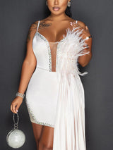 Close-up of the white mini dress with feather and bead details.