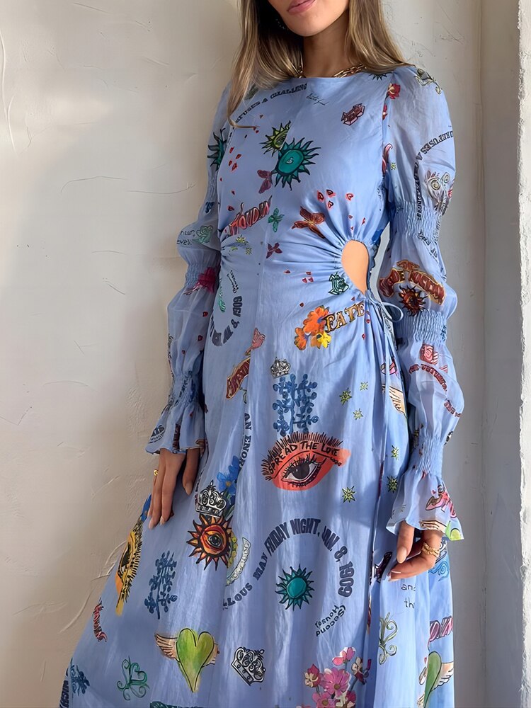 Side front view of a woman in a light blue graphic print maxi dress with cut-out waist detail and long, flared sleeves.