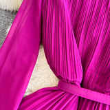 Detail of the pleated fabric on the bodice of a magenta dress.
