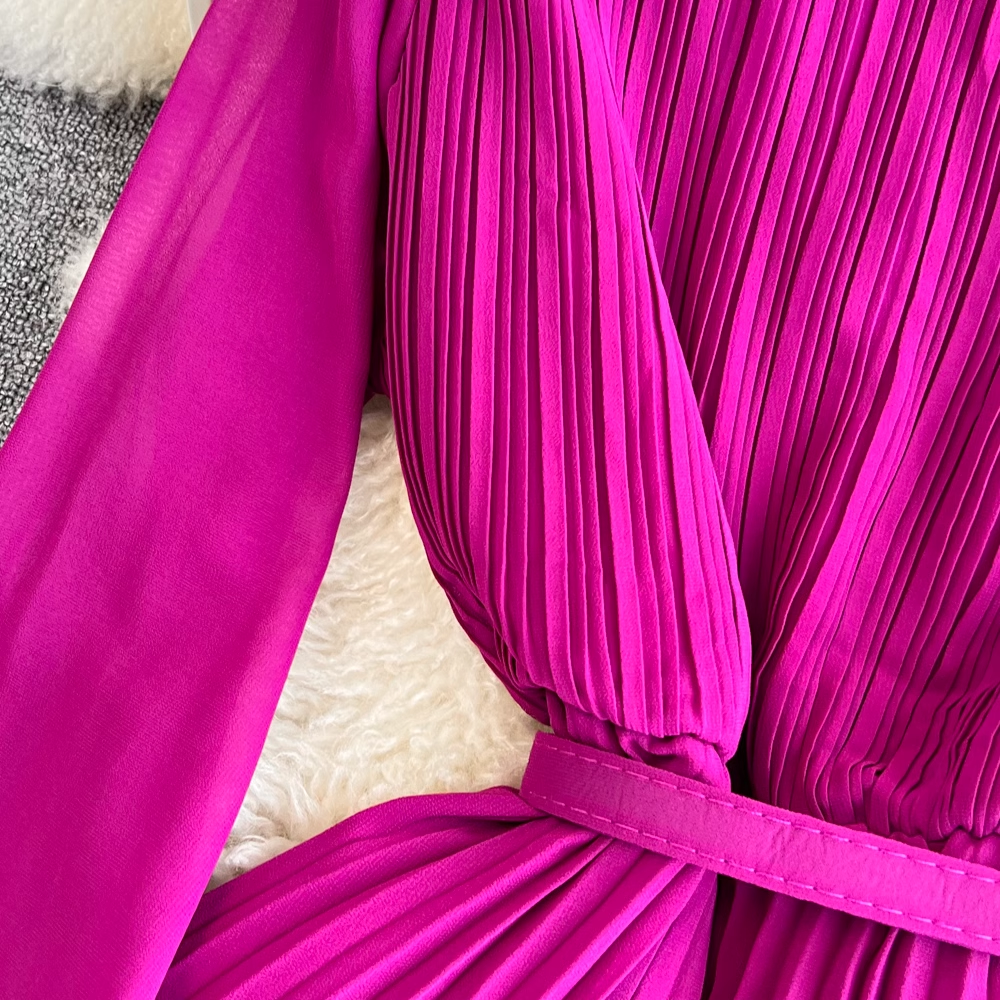 Detail of the pleated fabric on the bodice of a magenta dress.