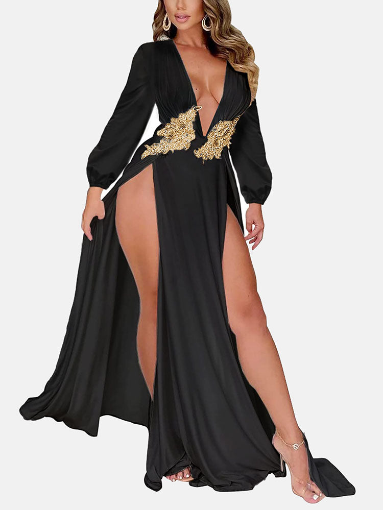 Woman wearing a long black dress with a deep V-neck and high leg slits, featuring gold embellishments on the bust.