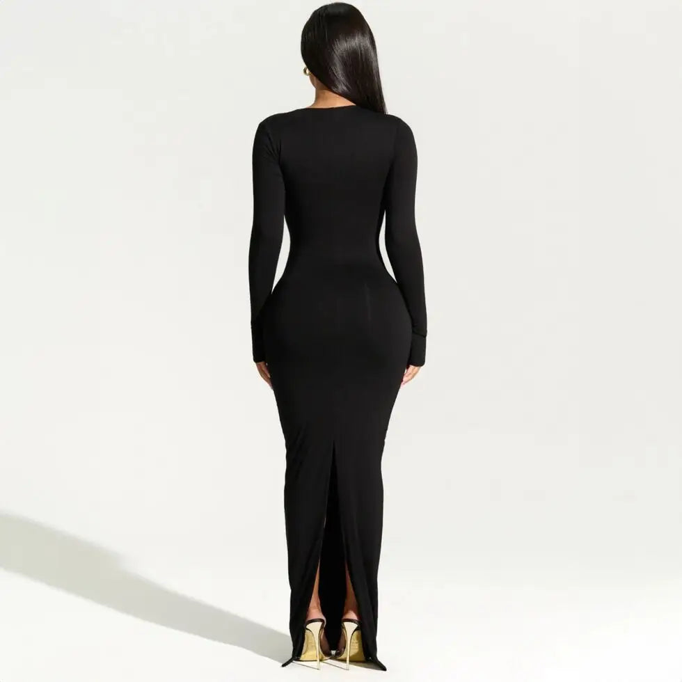 Back view of a woman wearing a black long-sleeved maxi dress with a high slit.