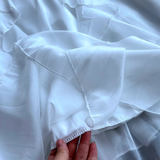 Detail of the ruffled hem of a white chiffon dress