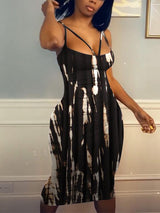 Woman in a black and white tie-dye midi dress, side view.