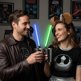 Couple wearing Chewbacca ear headbands and Star Wars themed t-shirts, toasting with metal cups