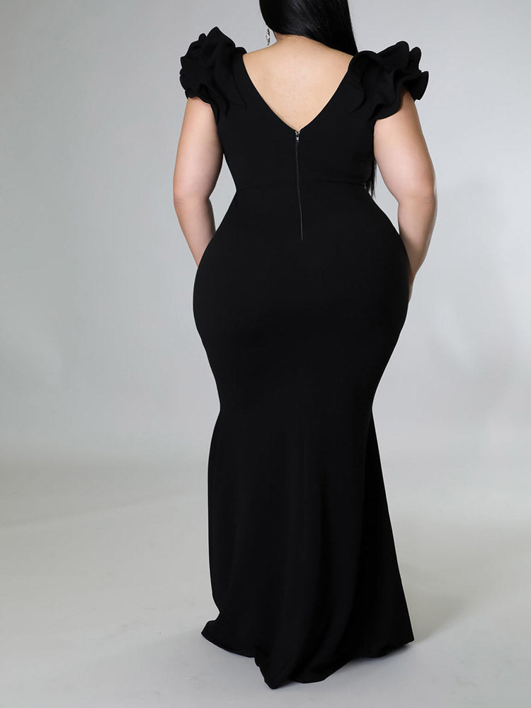 Plus-size model in an orange mermaid gown with ruffled sleeves.