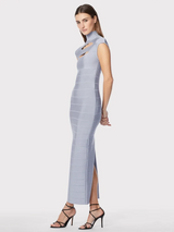 Side view of a model wearing a light blue sleeveless bodycon maxi dress with cut-out detail at the bust and high neckline, standing against a white background.
