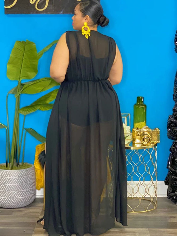 Woman wearing a black sheer maxi dress with high leg slits, back view