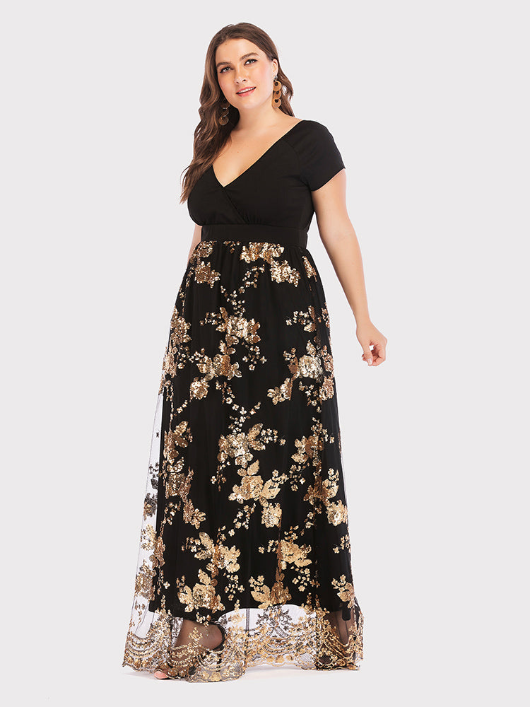 Three-quarter view of a plus-size model showcasing a black maxi dress with intricate gold floral sequins