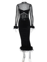 Black velvet midi dress with sheer sleeves and feather trim on a mannequin
