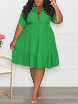 Woman wearing a vibrant green short-sleeved collared dress with a tiered hem and button-down front.
