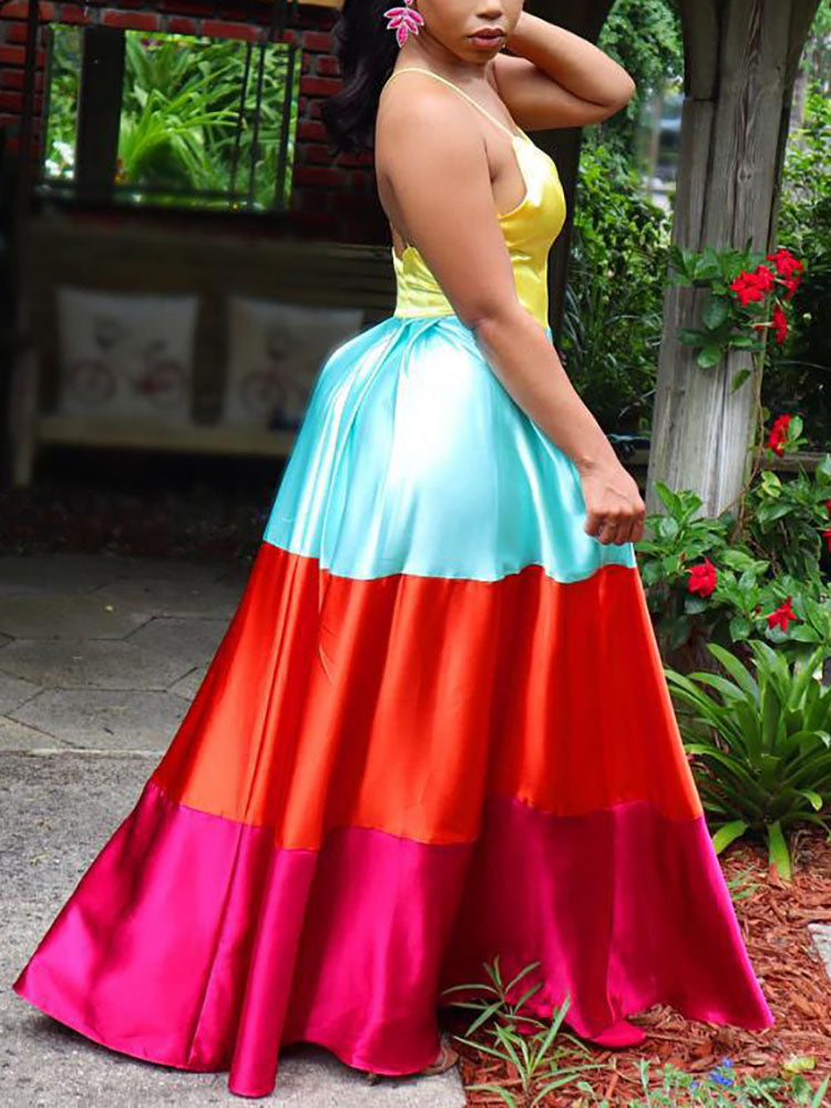Side view of a woman wearing a yellow, light blue, orange, and pink colorblock satin maxi dress.