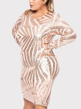 Close-up of a woman wearing a long-sleeved, knee-length sheath dress with a geometric sequin pattern in rose gold and white.