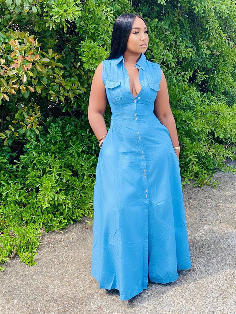 Woman wearing a blue denim maxi dress with a collared neckline and button-down front, standing outdoors.