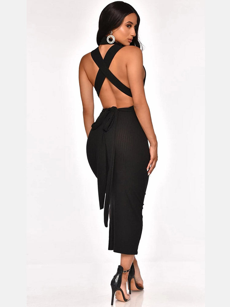 Woman wearing a black sleeveless mock neck ribbed knit sheath dress with a fitted waist and high heels, side view.