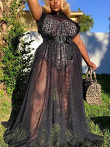 Woman wearing a leopard print top with a sheer black mesh overlay maxi skirt and a wide black belt, posing outdoors.