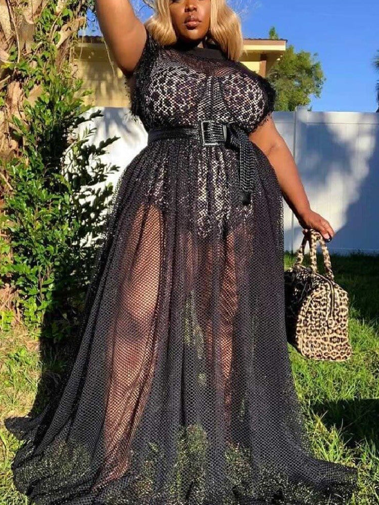 Woman wearing a leopard print top with a sheer black mesh overlay maxi skirt and a wide black belt, posing outdoors.