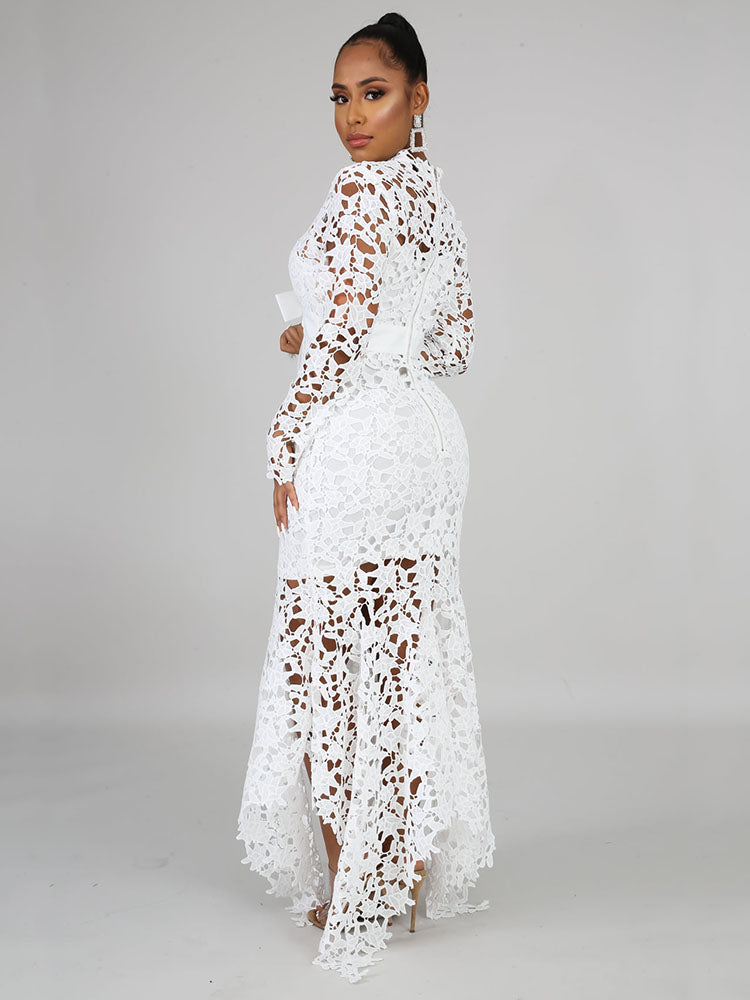Back view of a woman wearing a white long-sleeved lace mermaid dress with a high neckline and a sash.