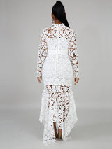 Rear view of a woman in a white lace maxi dress with a high neckline and long sleeves, showcasing the zipper closure.