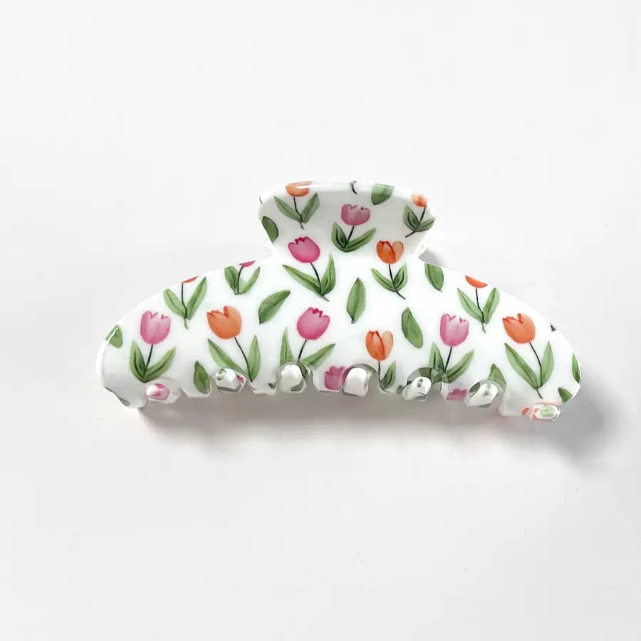 Top view of a white claw clip with a pink and orange tulip floral print