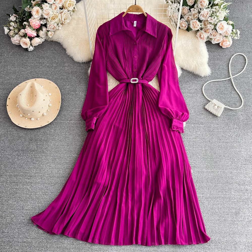 Magenta pleated midi dress with a collared neckline and long puff sleeves, laid flat with a straw hat and pearl-adorned handbag.