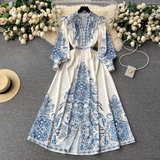 A flat lay of the white maxi dress with blue paisley print, styled with decorative elements for a visually appealing presentation.