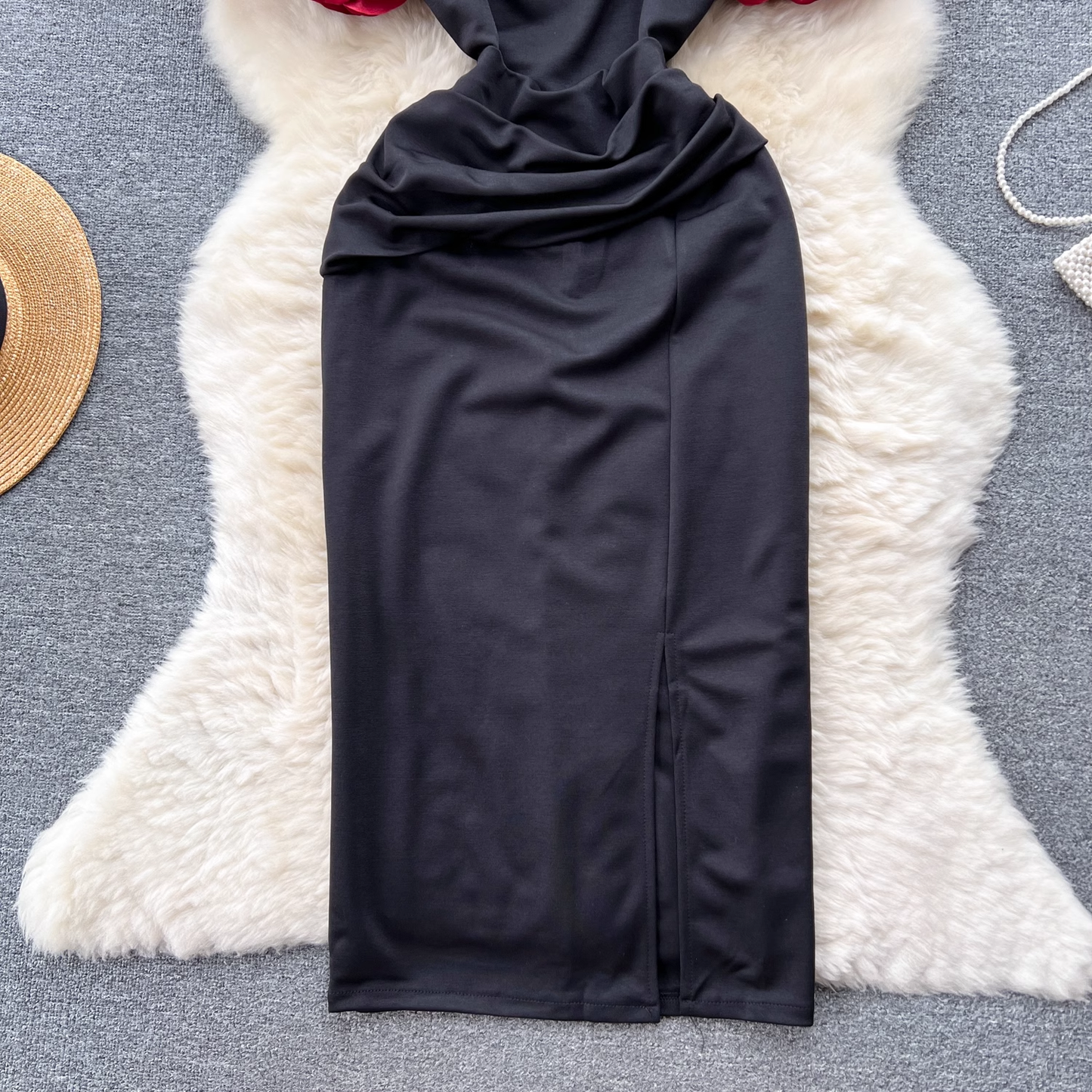 Detail of the ruched skirt and slit on the black dress