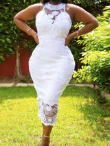 Front view of a woman in a white lace midi dress with floral details and a sheer hem.